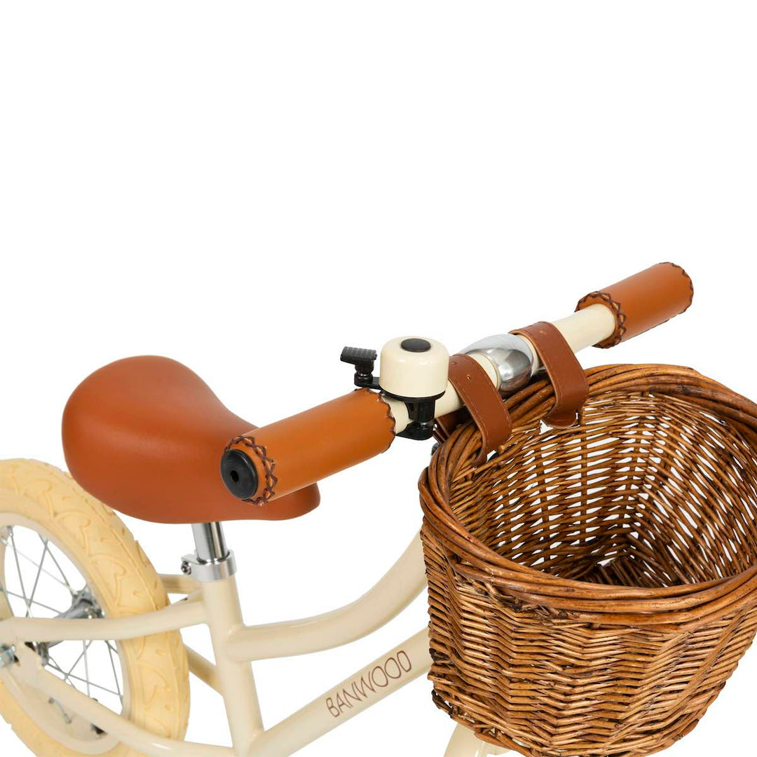 close up of the Cream Banwood First Go Balance Bike wicker basket and bell