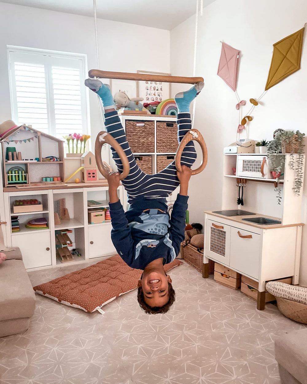 Child playing with a Lillagunga Acrobat toy in a playroom.