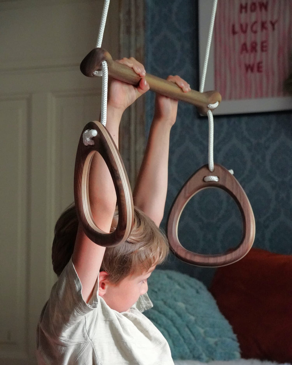 Child playing with wooden gymnastic rings indoors