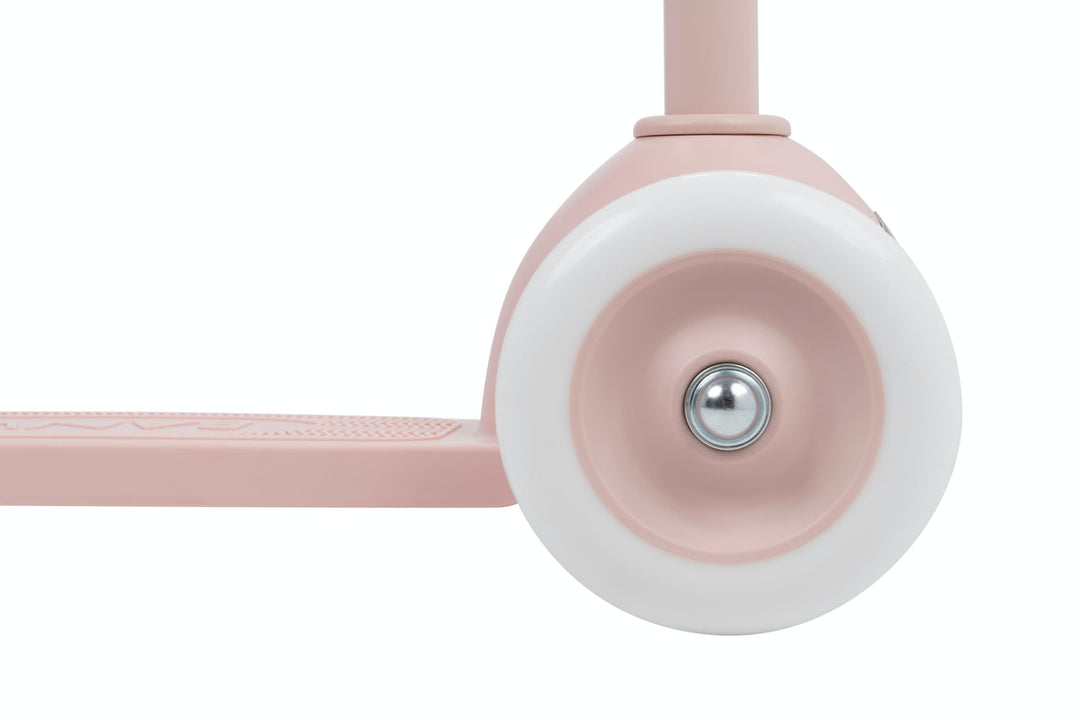 Close-up of a pink scooter wheel with white rim on a white background
