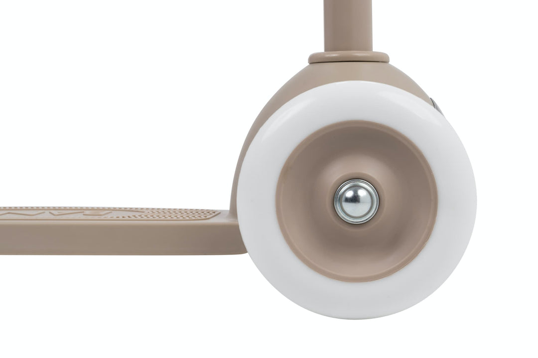 Close-up of a beige and white scooter wheel on a white background