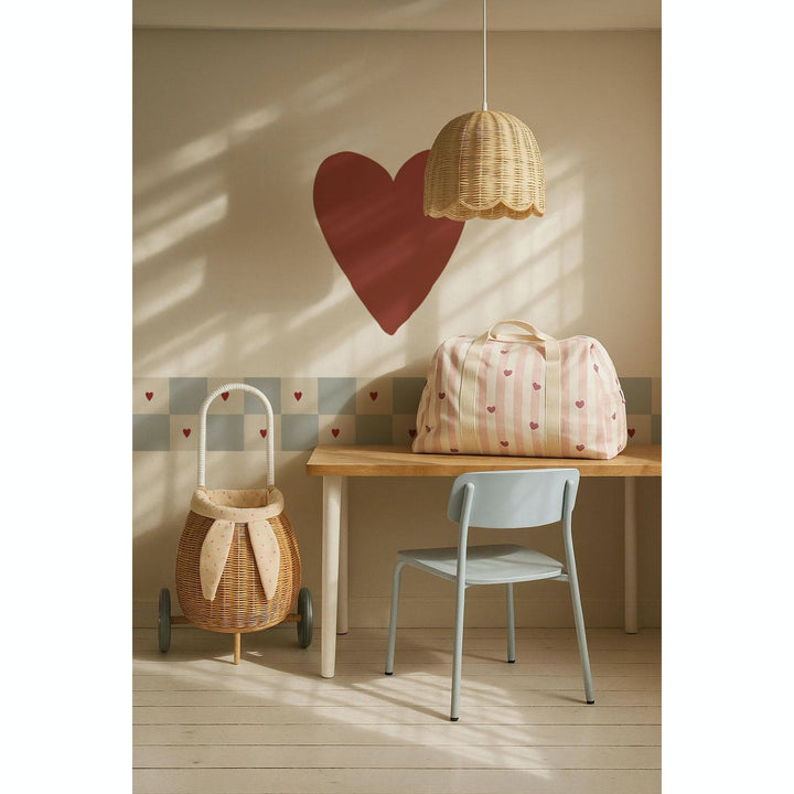 Children's room with a heart-shaped wall decoration, wicker basket, and chair.