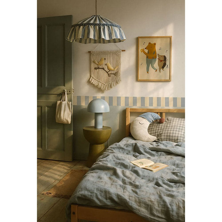 Children's bedroom with a bed, lamp, and wall decorations.