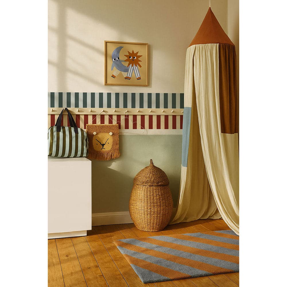 Children's room with striped bed, decorative pillows, and a woven basket.