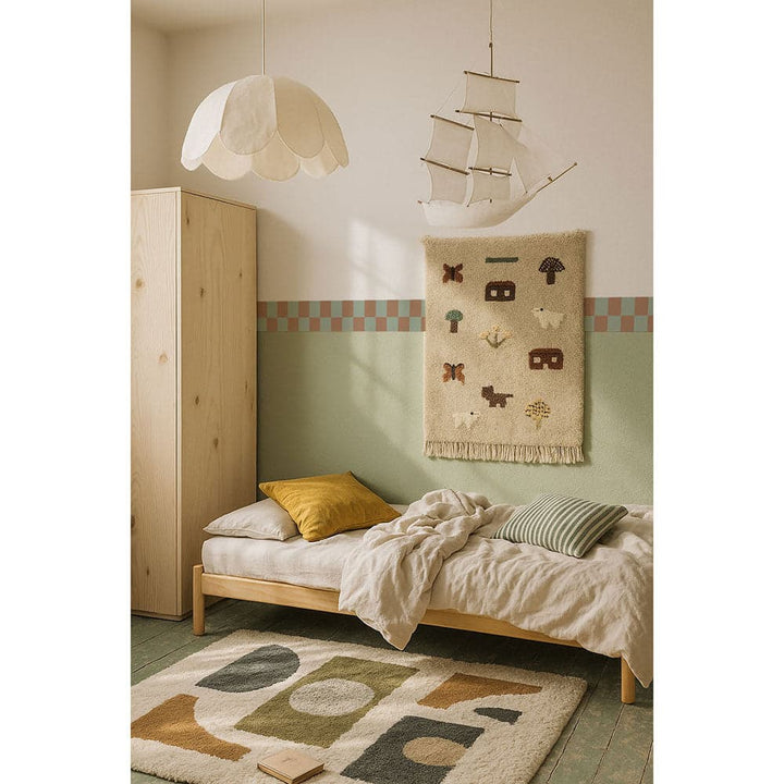 Children's bedroom with wooden bed, yellow pillow, and decorative rug.