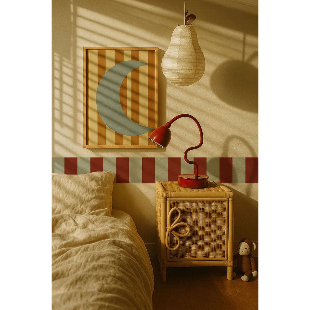 Nursery room with a red lamp, wicker basket, and framed picture of a moon on a striped wall.