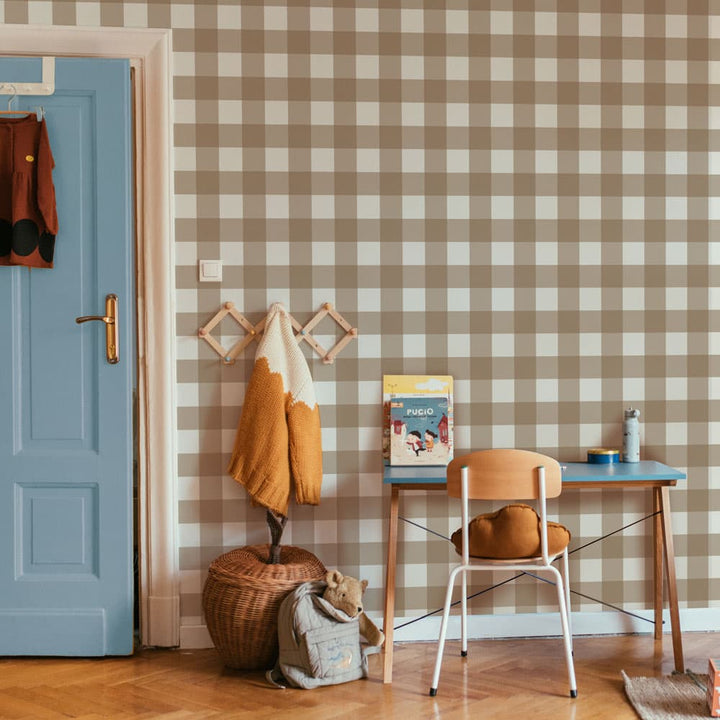 Room interior with checkered wall, blue door, and wooden furniture.