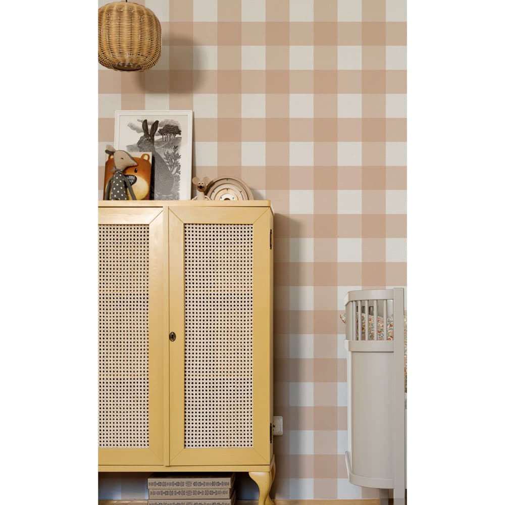 Yellow cabinet with wicker door against a checkered wall