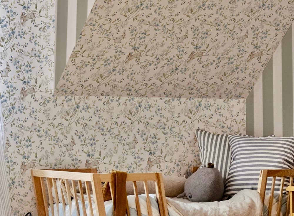 Living room with floral wallpaper, striped sofa, and wooden chairs.