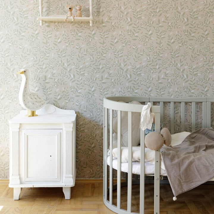 Nursery room with a white crib and side table against a textured wall.