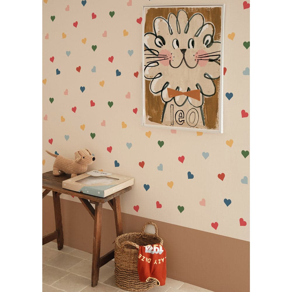 Children's room with heart-patterned wallpaper, a framed picture of a cat, a wooden stool, and a basket.