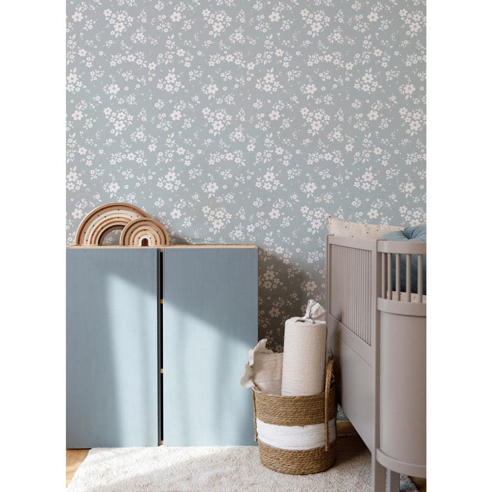 Nursery room with floral wallpaper, crib, and storage unit.