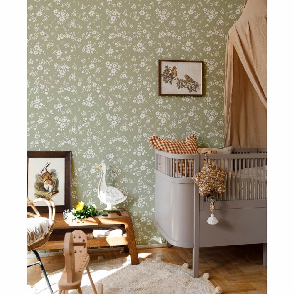 Nursery room with floral wallpaper, crib, and decorative elements.
