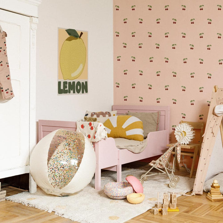 Children's room with pink bed, lemon-themed decor, and cherry wallpaper.