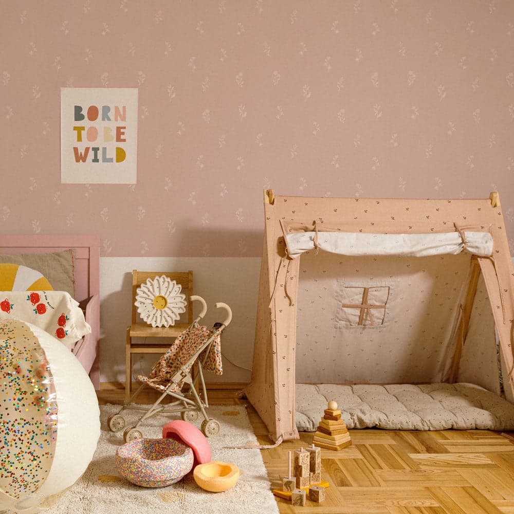Children's room with a wooden play tent, toys, and a 'Born to be Wild' poster on a pink wall.