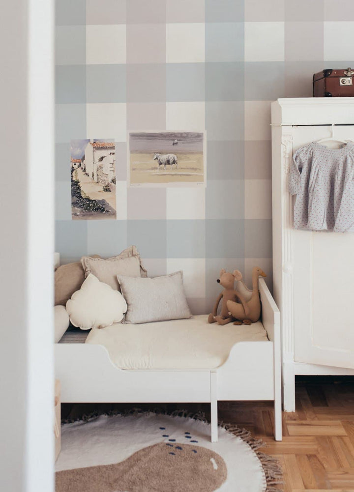 Children's bedroom with checkered wall, bed, teddy bear, and rug.
