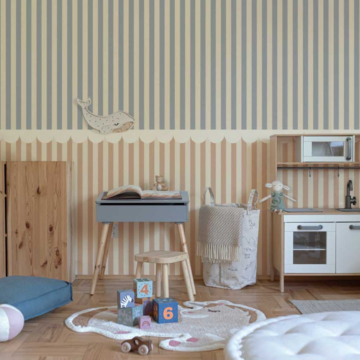 Children's playroom with striped wallpaper, wooden furniture, and toys on a wooden floor.