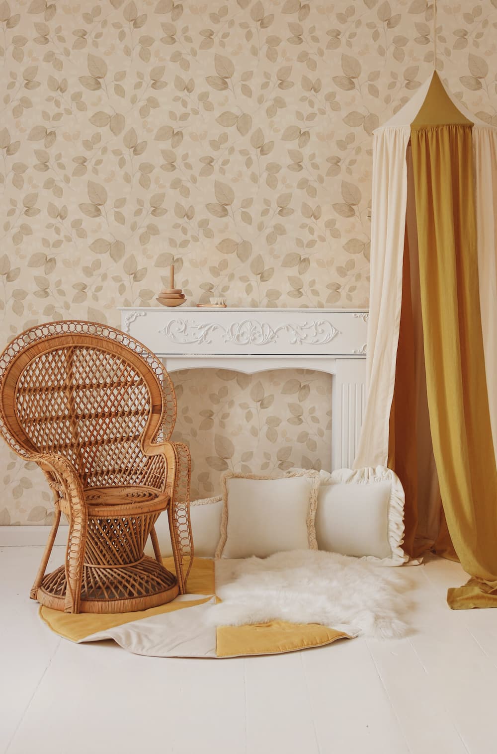 Cozy room with wicker chair, floral-patterned wallpaper, and draped curtains.
